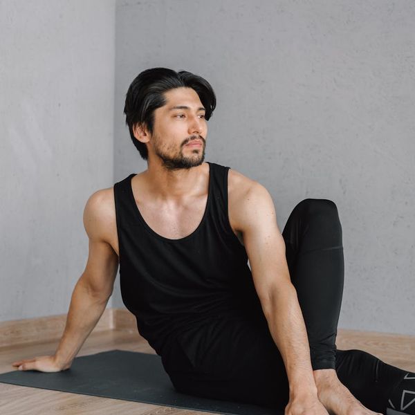 A focused man meditating after a workout session, calm expression.